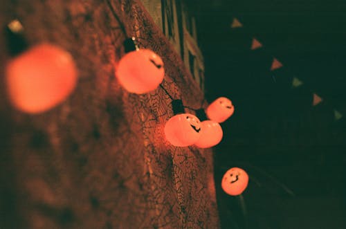 Glowing pumpkin lamps hanging on wall during Halloween celebration