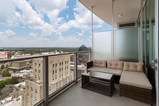A serene city balcony featuring modern furniture and a wide view of the urban skyline.