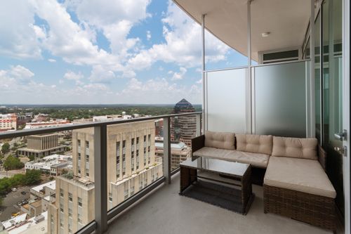 Free A serene city balcony featuring modern furniture and a wide view of the urban skyline. Stock Photo