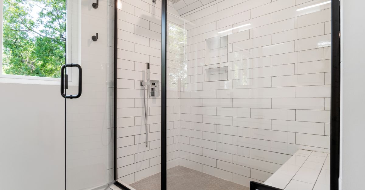 Sleek and modern shower with glass panels and tiled walls in a bright bathroom.