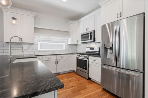 Free A sleek, modern kitchen featuring white cabinets and stainless steel appliances, ideal for a contemporary home. Stock Photo