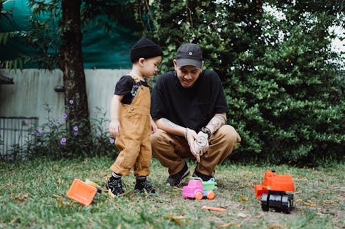 Free A Father and Son Looking at the Toys on the Grass Stock Photo