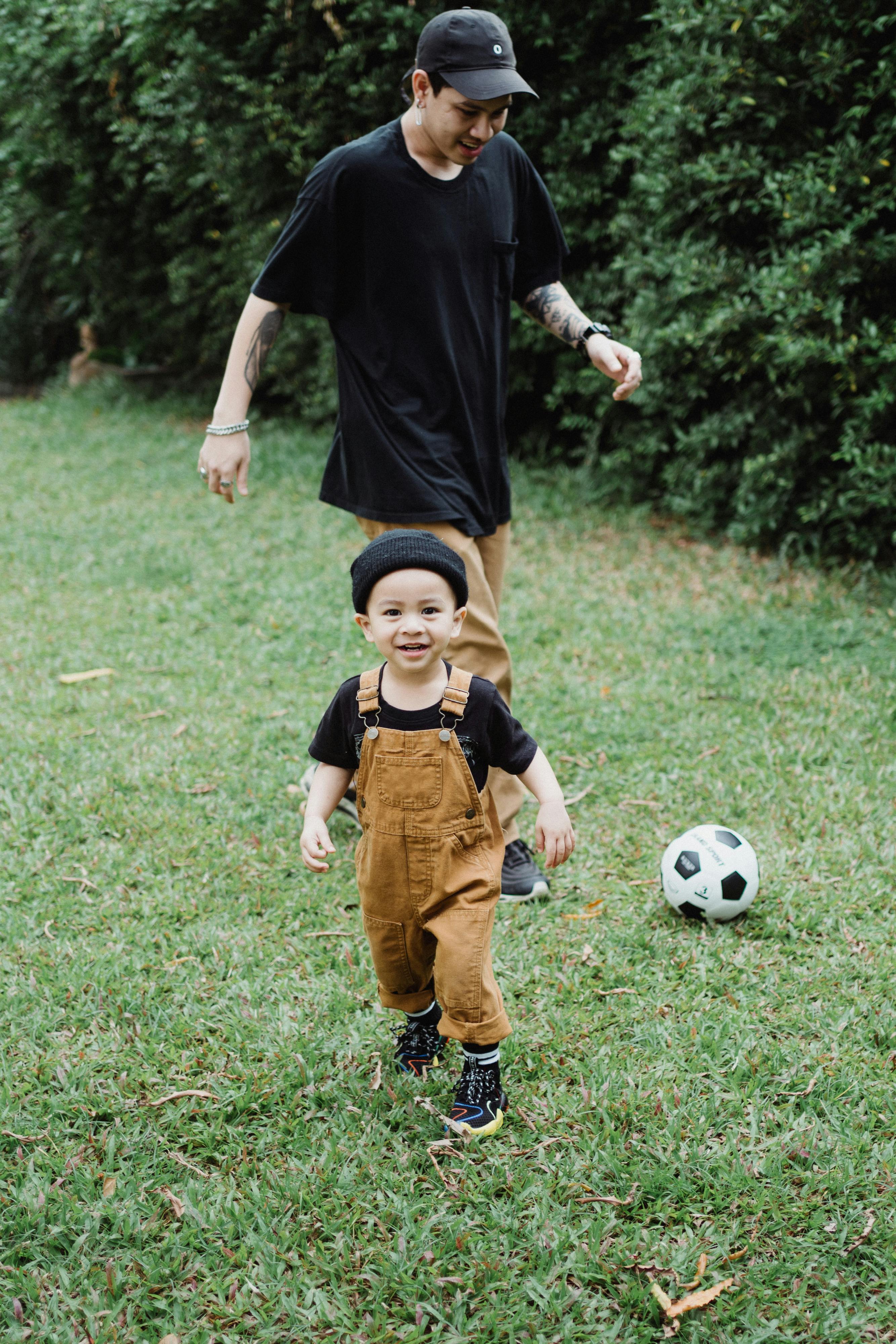 father and son playing football in the backyard