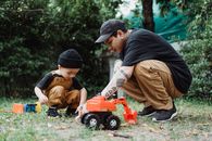 Man and Boy Playing with Plastic Toys in Patio