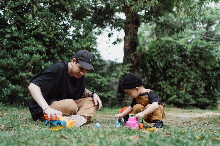 Father And Son Playing With Toy Cars Outside