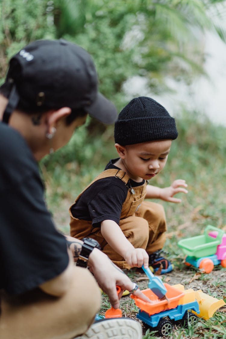 Boy Wearing A Beanie Playing With Toy Trucks