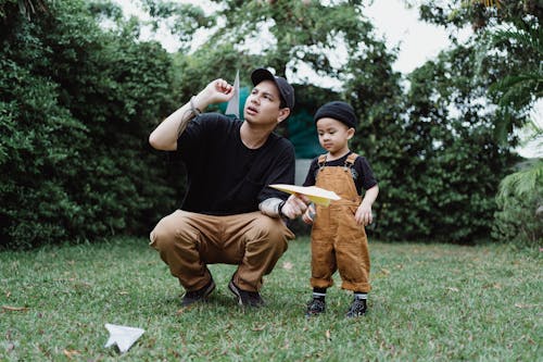 Free Man with a Child Playing Paper Airplanes Stock Photo