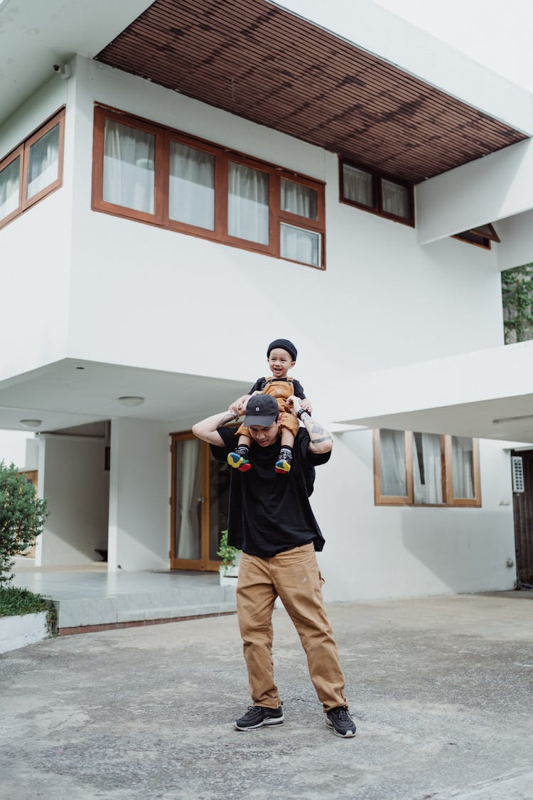 Man Carrying Happy Boy On Shoulders