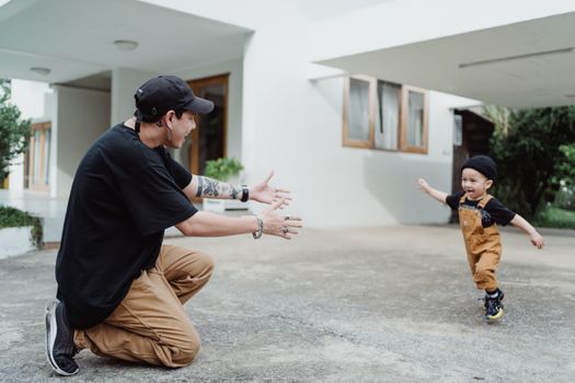 Shot of a Man Playing with a Boy in Front of a House