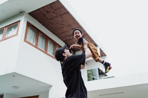 Father Playing with Son Outside House