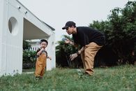 Father and Son Playing in the Backyard Blowing Bubbles 