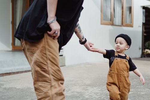 Free A father and son spending quality time together walking outdoors in matching outfits. Stock Photo