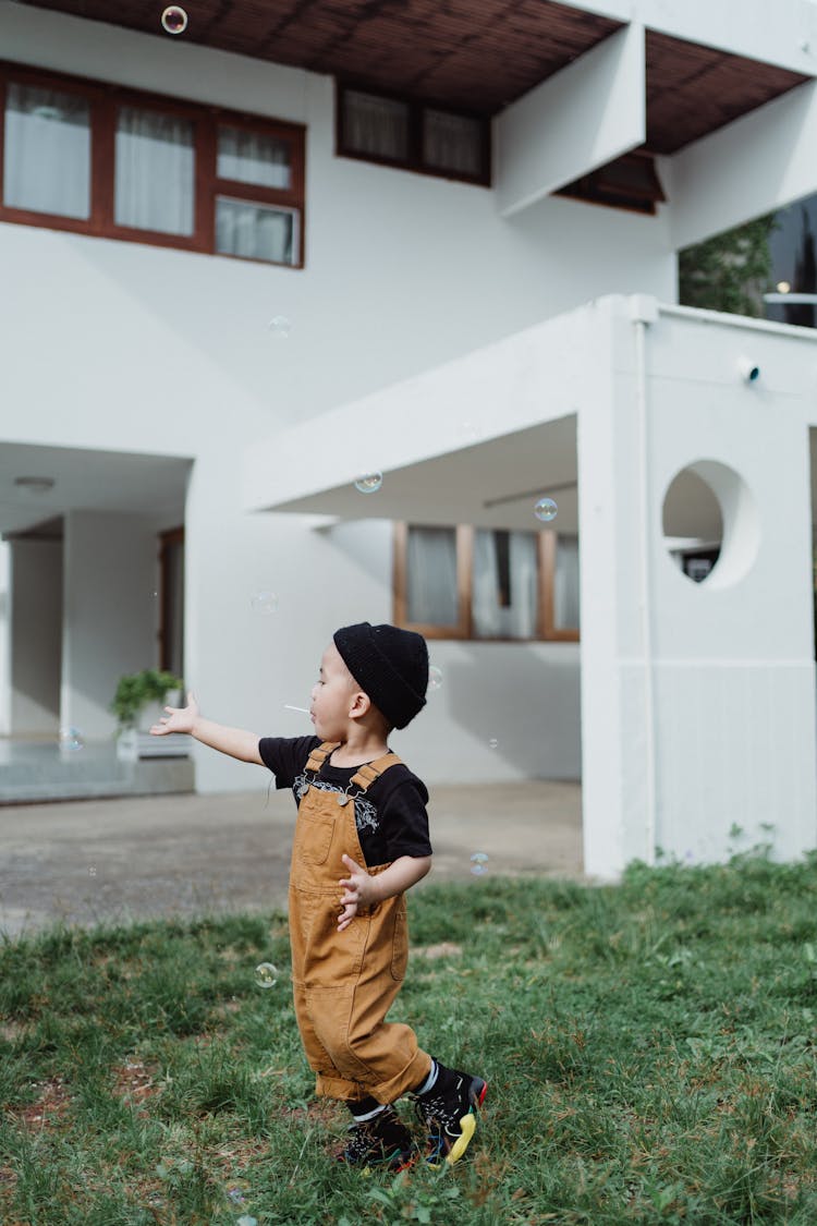 Little Boy Running In Front Of House 