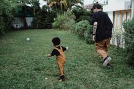 Boy in Black T-shirt and Brown Shorts Playing Soccer