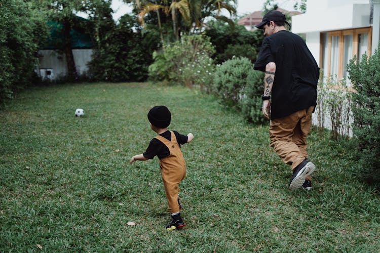 Father And Son Playing Football In The Backyard 