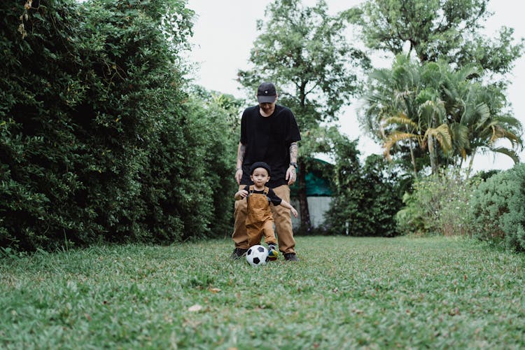 Boy Playing Ball With His Father In Yard