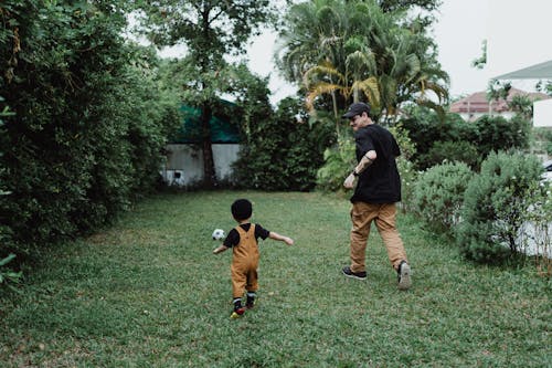 Father and Son Playing Football in the Backyard 