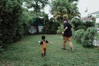Man in Black T-shirt and Brown Pants Playing With Boy in Brown T-shirt during