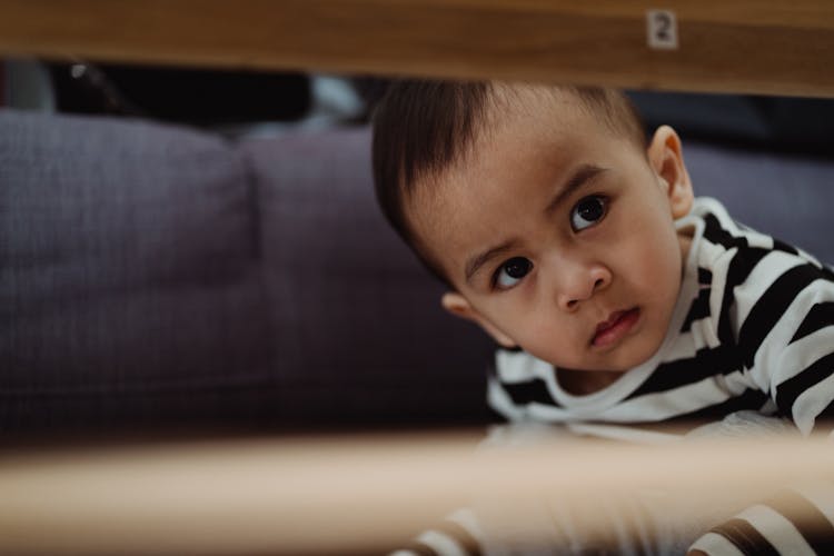 Boy Lurking Under Table