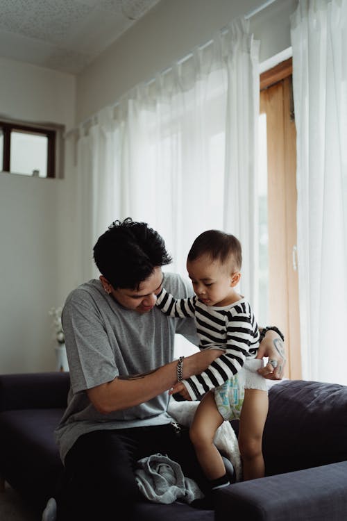 Man Changing His Sons Diaper 