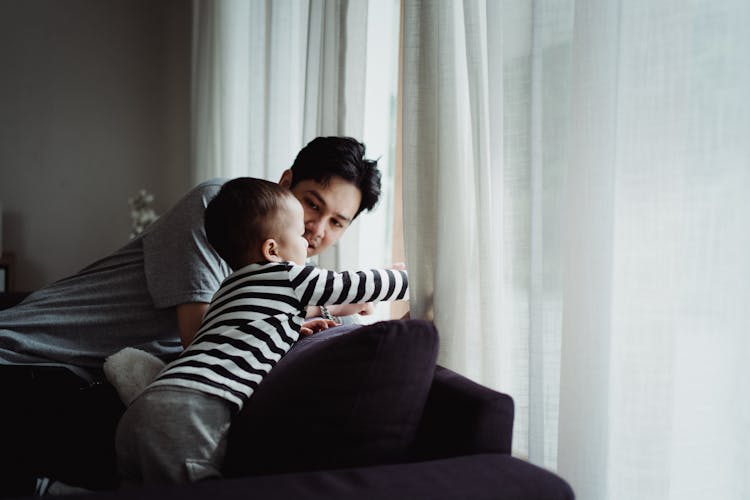 Father And Son Looking Out The Window 