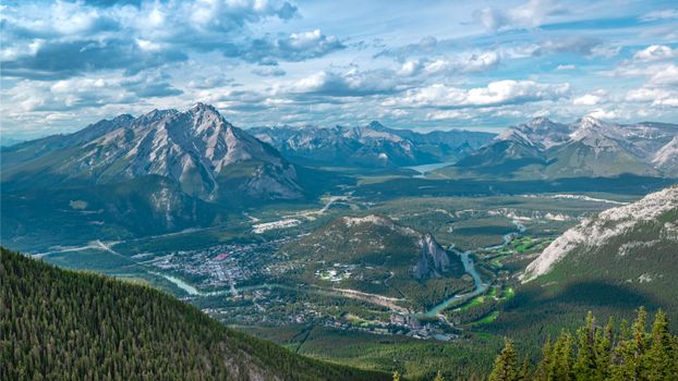 Picturesque view of snowy mountains and green valley against cloudy sky in countryside