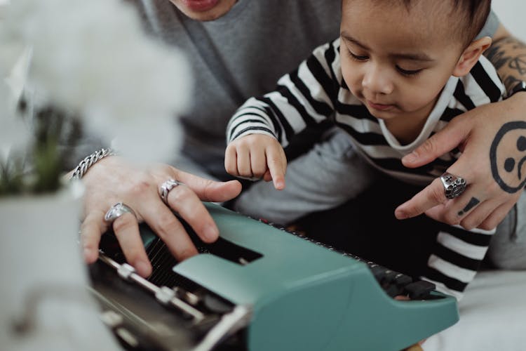 Father And Son Writing On A Vintage Writing Machine 