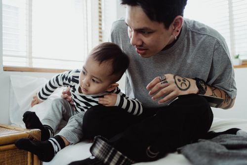 Free A father and son share a tender moment on a bed, highlighting familial bonds. Stock Photo