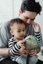 Man in Gray Crew Neck Shirt Carrying Baby in Black and White Striped Long Sleeve Shirt