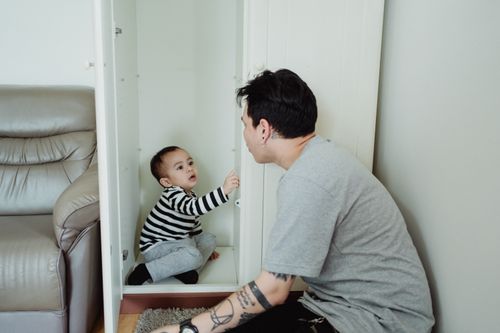 Free Father and baby bonding with playful moments indoors beside a comfortable couch. Stock Photo