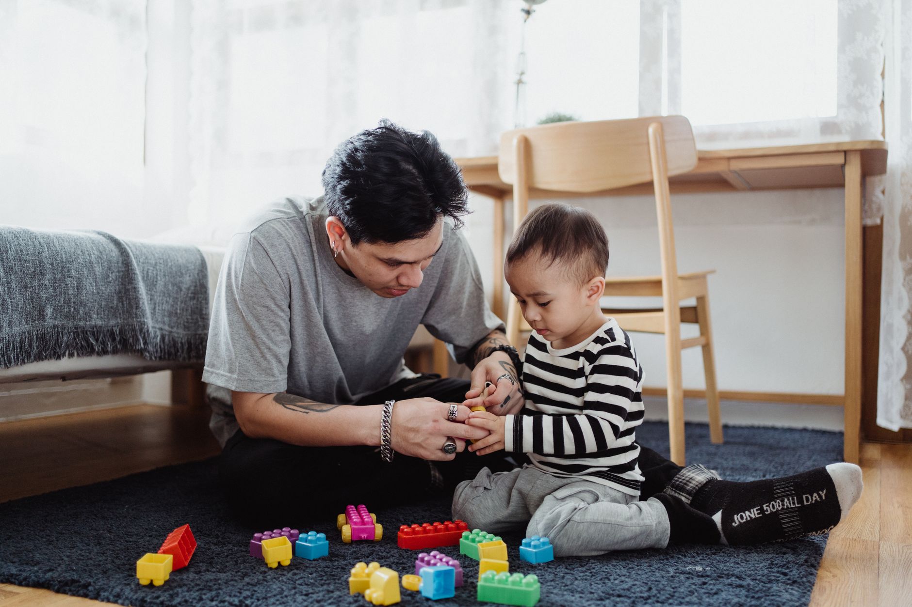 Parent playing with child using colorful blocks