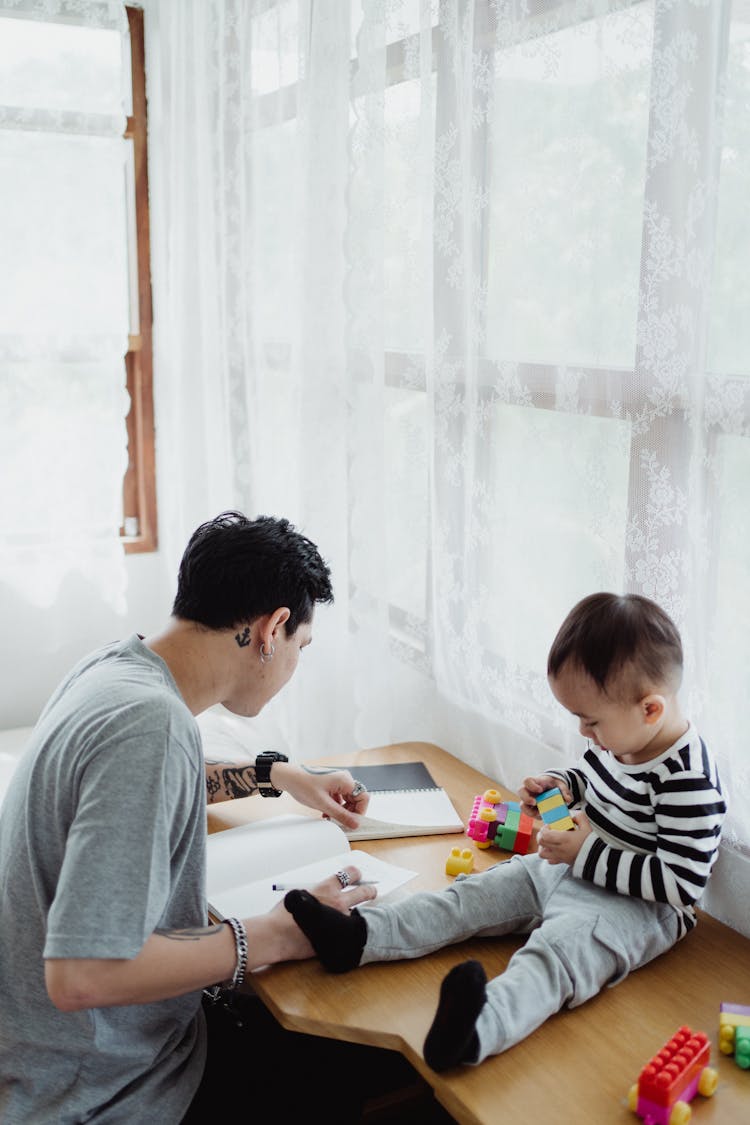 Man With Son Working By Desk