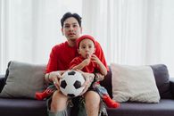Boy in Red Crew Neck T-shirt Sitting on Brown Sofa