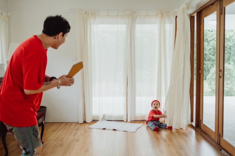 Father And Son In Matching Outfits Playing Indoors 