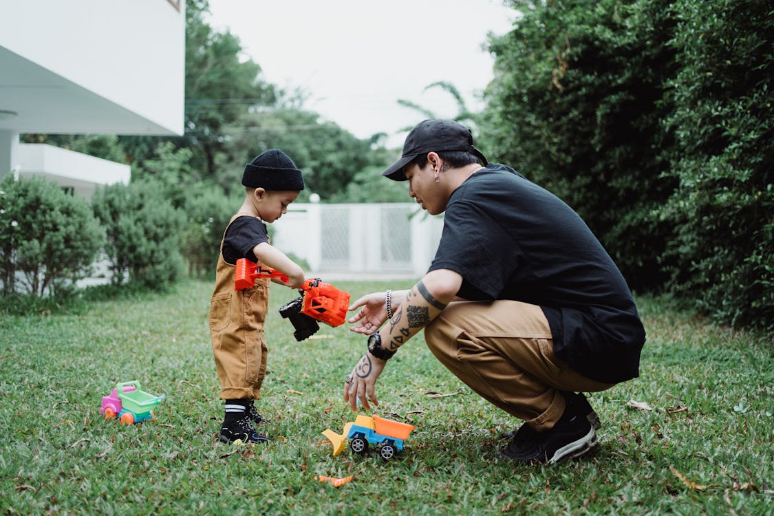 Man in Black T-shirt and Brown Pants Holding Orange and Black Toy Gun