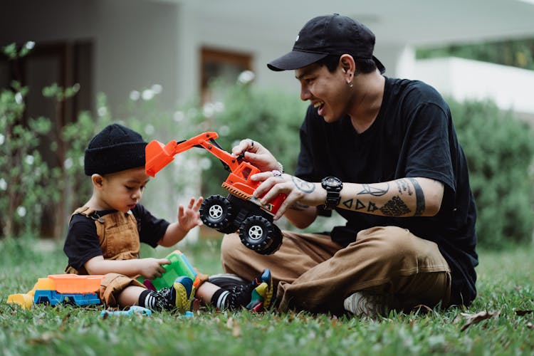 Man And Boy Playing With Toys In Yard