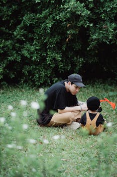 一对父子在绿植环绕的草地上享受美好时光