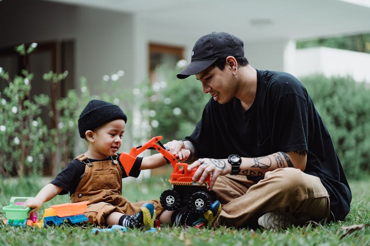 Father And Son Playing With Toy Cars Outdoors 