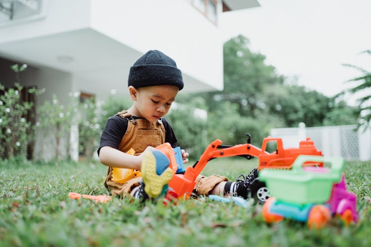 A Boy Playing With Toys In The Yard