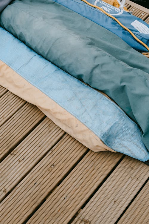 Blue and White Textile on Brown Wooden Floor