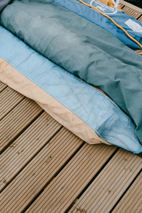Free Stacked boat covers on a wooden dock, showcasing vibrant colors and nautical themes. Stock Photo