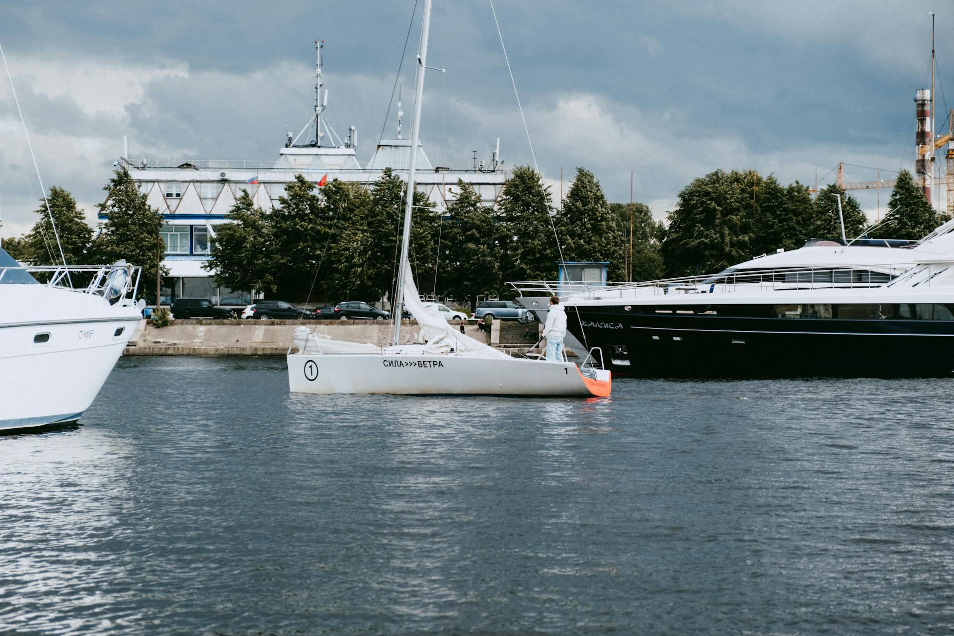 Sailboats and yachts moored at a marina on a cloudy day, showcasing nautical lifestyle.