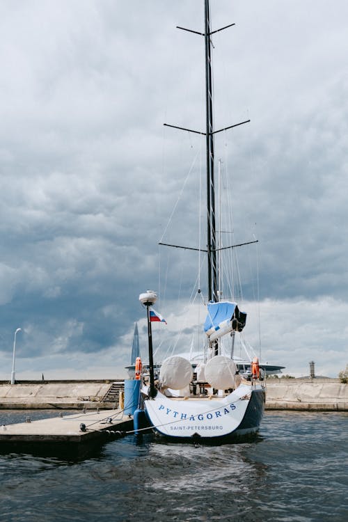 Weißes Und Blaues Boot Auf Dock Unter Bewölktem Himmel