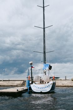 White and Blue Boat on Dock Under Cloudy Sky