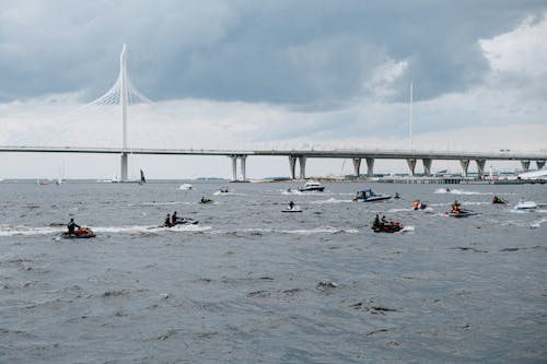 People Riding on Boat on Sea Under White Clouds