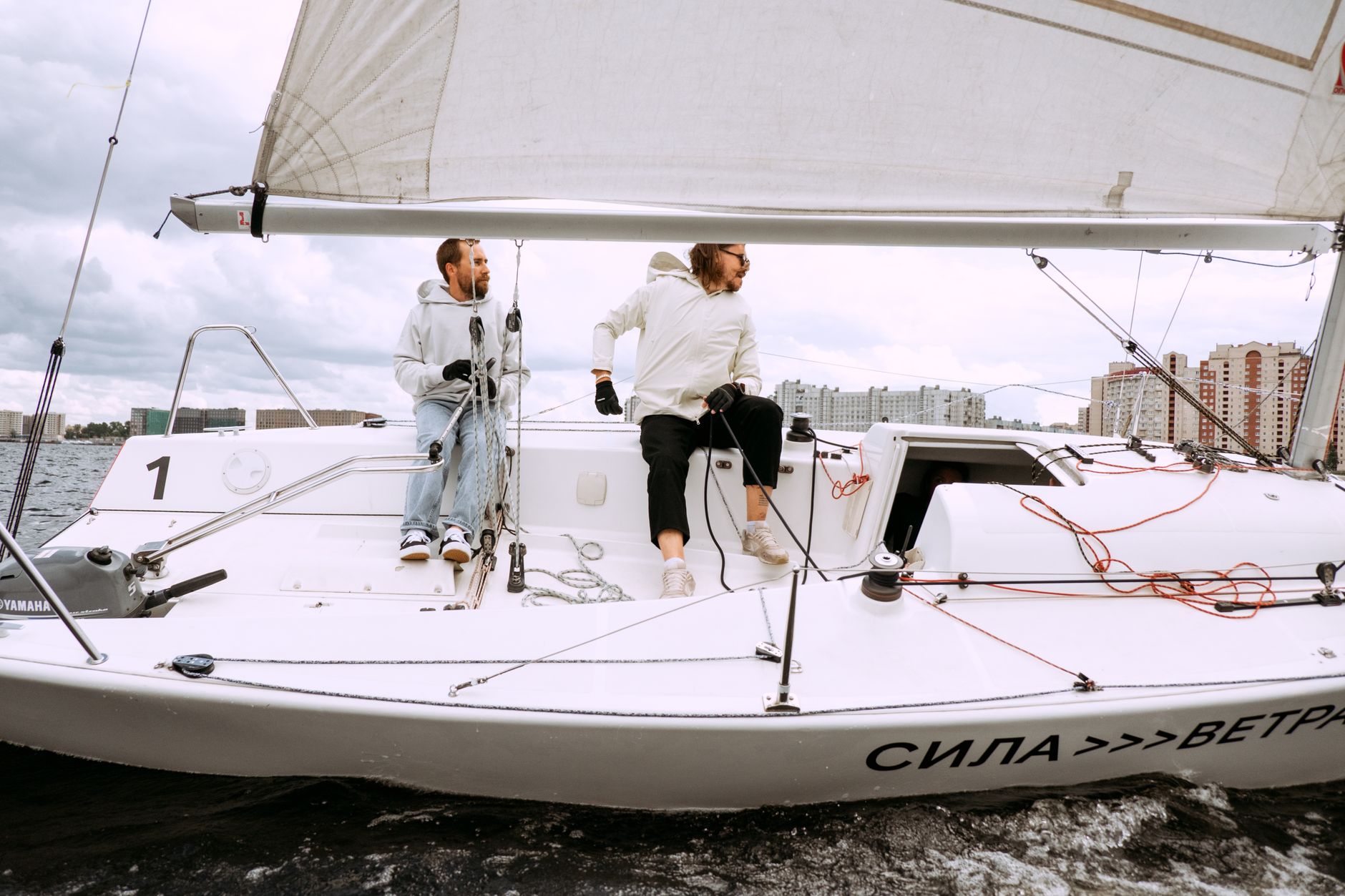 Two men yachting on a sailboat, capturing the excitement of sailing on open water. — free online jigsaw puzzle on JigsawPuzzlesFreeOnline.org