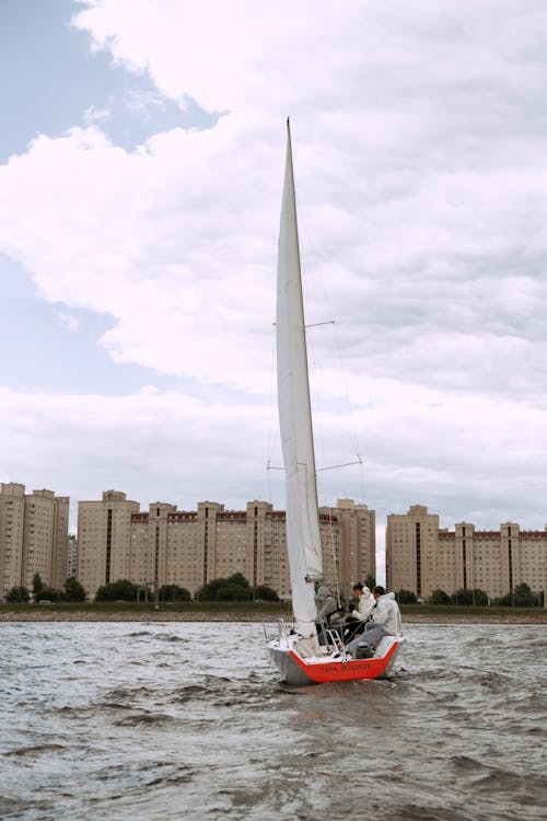 Person Riding on Red and White Boat on Water