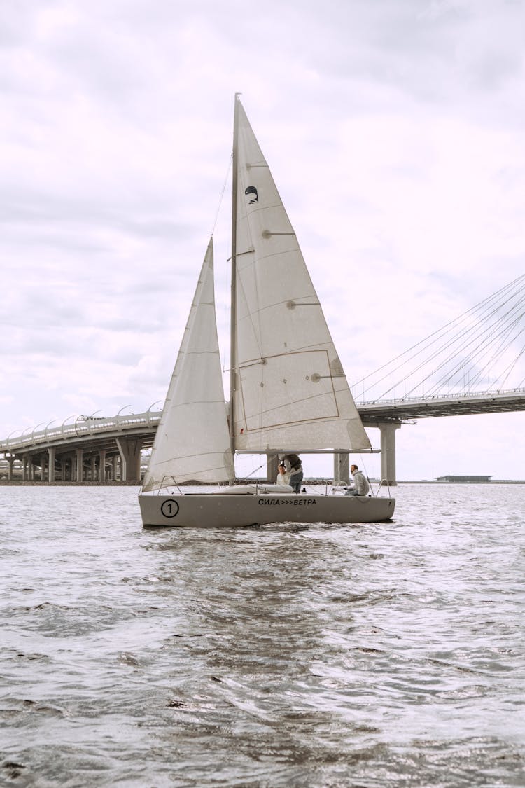 White Sail Boat On Sea Under White Sky