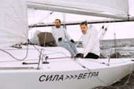 Man in White Shirt Sitting on White Boat