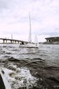 White Boat on Sea Near Bridge Under Cloudy Sky